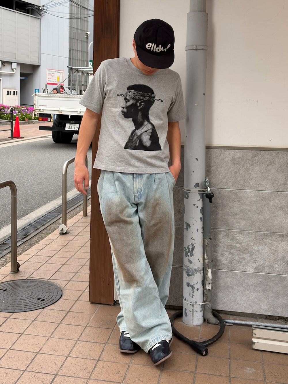 グレー系のTシャツ/カットソー、ブルー系のデニムパンツ、ブラック系のスニーカーを着用したメンズの夏コーディネートの2枚目の写真