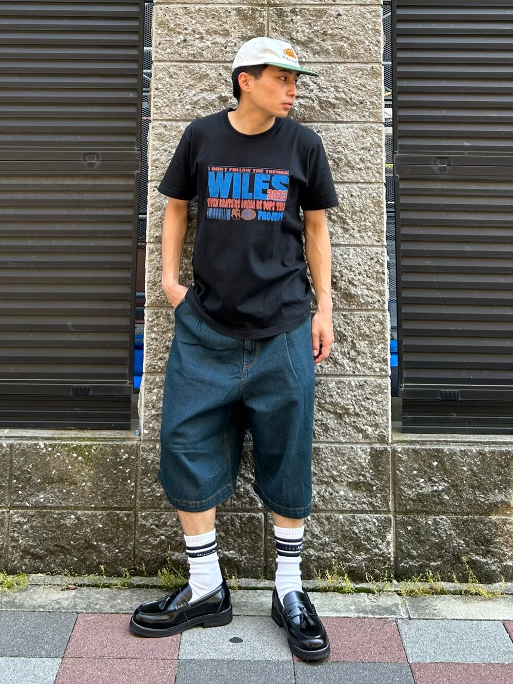 ブラック系のTシャツ/カットソー、ブルー系のデニムパンツ、ブラック系のローファーを着用したメンズの夏コーディネートの2枚目の写真