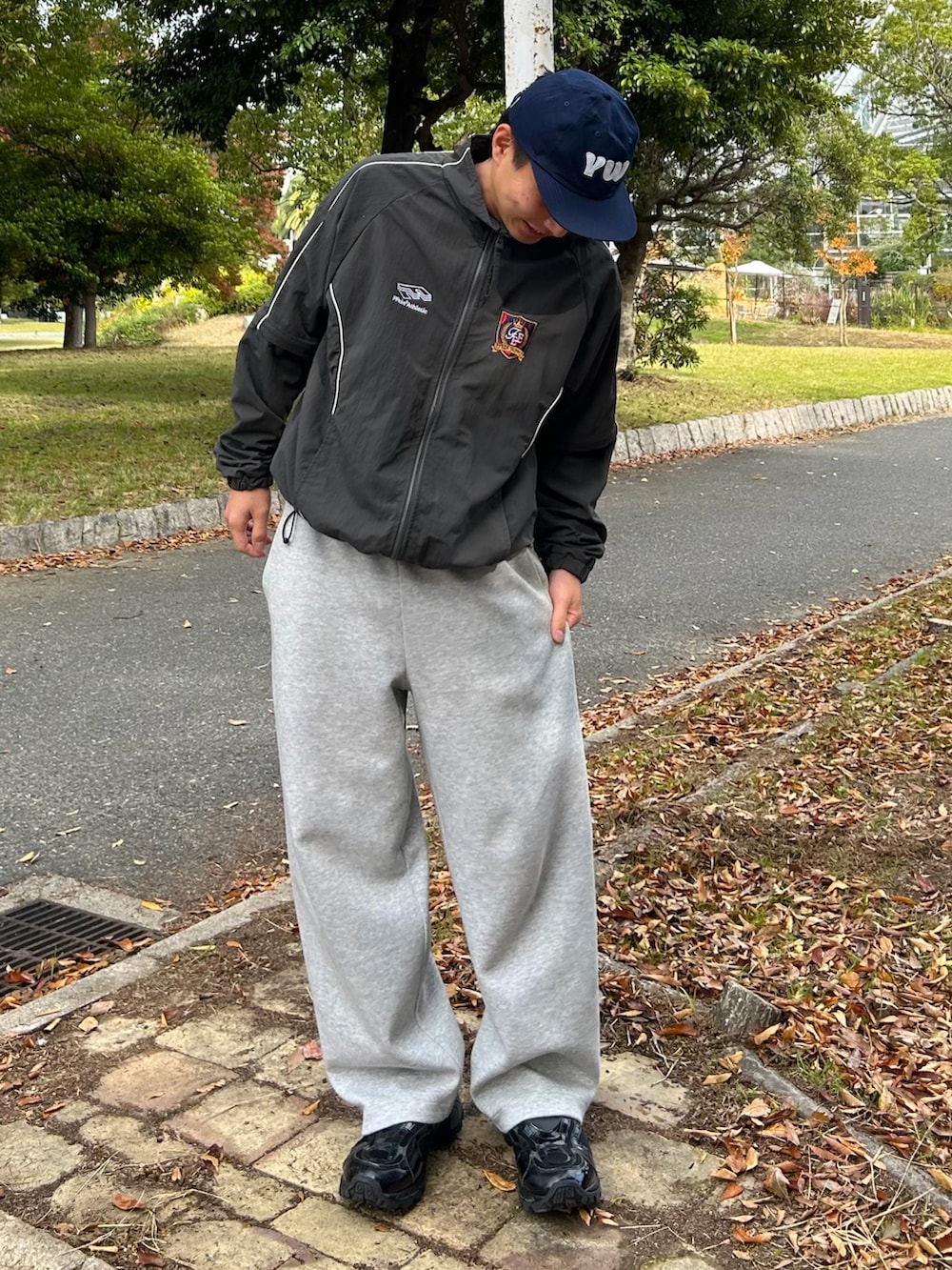 グレー系のナイロンジャケット、グレー系のスウェットパンツ、ブラック系のスニーカーを着用したメンズの冬コーディネートの3枚目の写真