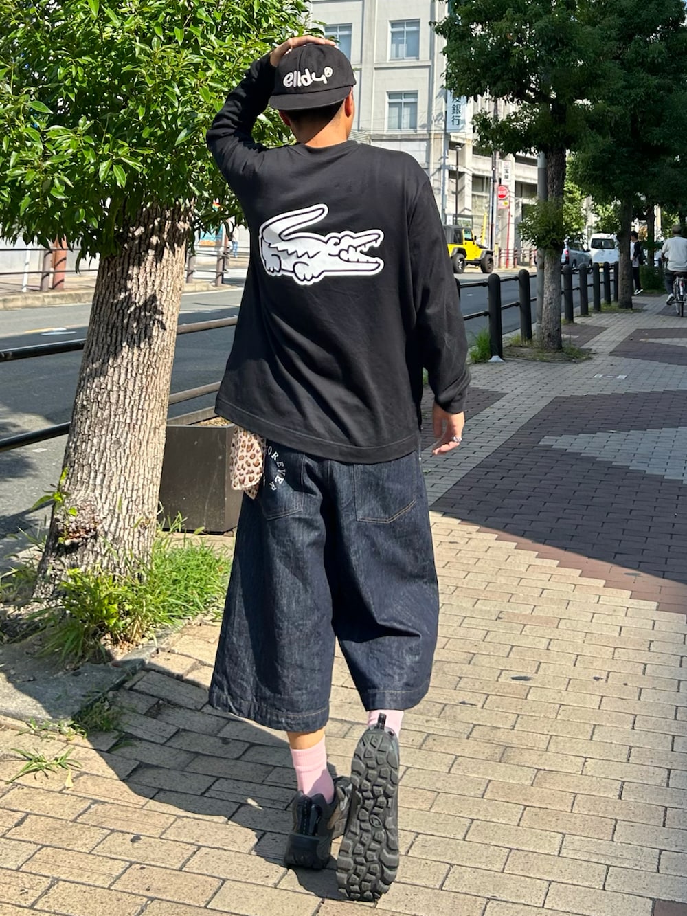 ブルー系のデニムパンツ、ブラック系のTシャツ/カットソー、ブラック系のスニーカーを着用したメンズの秋コーディネートの2枚目の写真