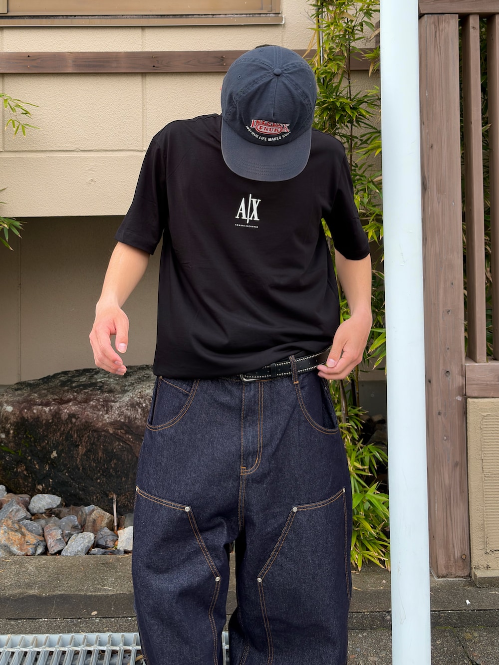 ブラック系のTシャツ/カットソーを着用したメンズの春コーディネートの2枚目の写真