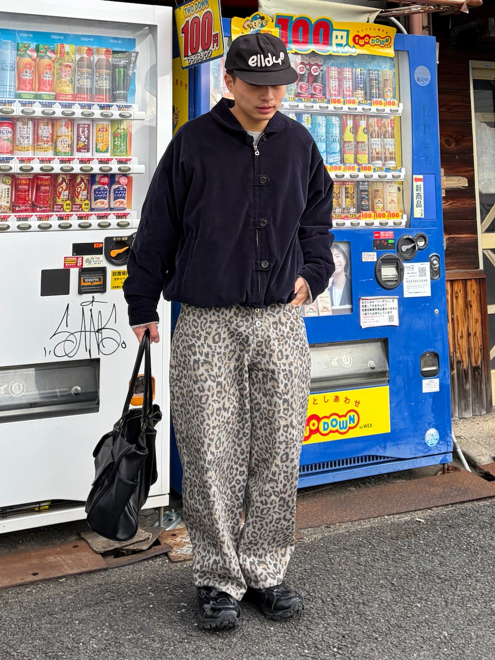 イエロー系のその他パンツ、ブラック系のボストンバッグ、ブルー系のジャケット/アウターを着用したメンズの冬コーディネートの2枚目の写真