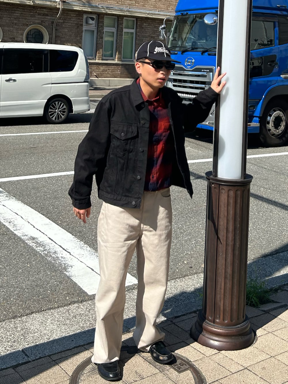 ベージュ系のデニムパンツ、ブラック系のローファー、レッド系のシャツ/ブラウスを着用したメンズの秋コーディネートの2枚目の写真