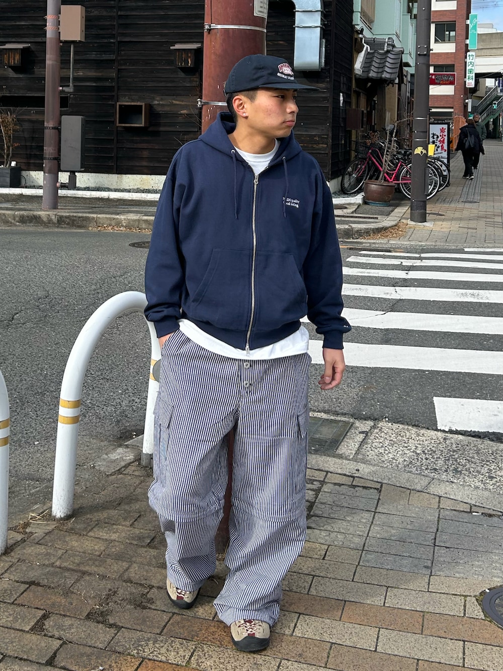 ブルー系のパーカー、ブラック系のカーゴパンツ、ベージュ系のスニーカーを着用したメンズの冬コーディネートの2枚目の写真