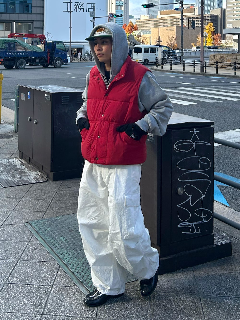 レッド系のダウンベスト、ホワイト系のその他パンツ、ブラック系のローファーを着用したメンズの冬コーディネートの2枚目の写真