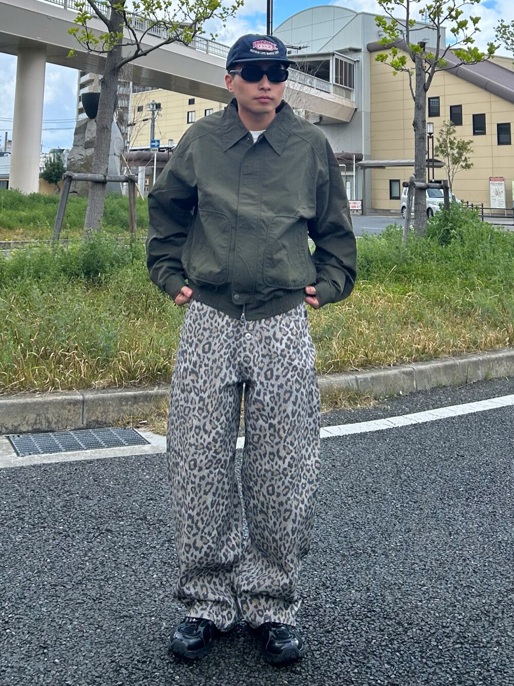 グリーン系のテーラードジャケット、イエロー系のその他パンツ、ブラック系のスニーカーを着用したメンズの春コーディネートの2枚目の写真