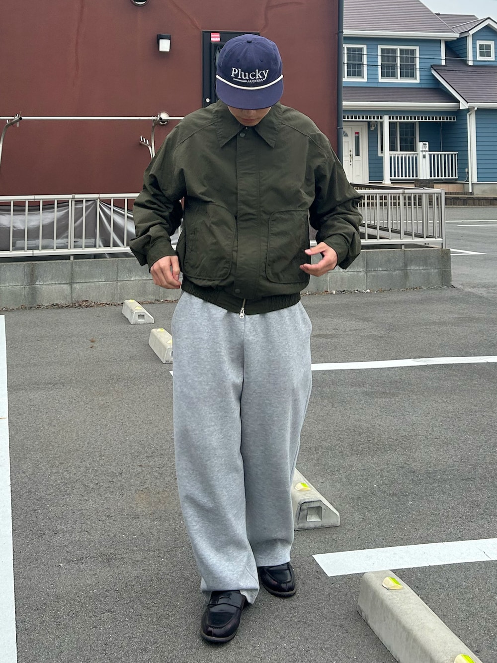 グリーン系のテーラードジャケット、グレー系のスウェットパンツ、ブラウン系のローファーを着用したメンズの春コーディネートの2枚目の写真