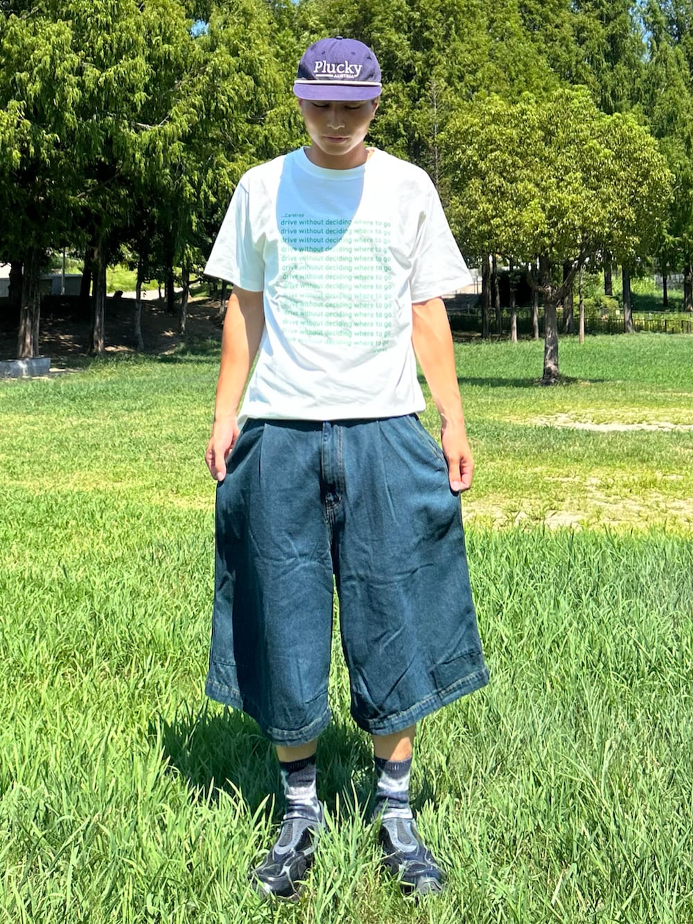 グリーン系のTシャツ/カットソー、ブルー系のデニムパンツ、ブラック系のスニーカーを着用したメンズの秋コーディネートの2枚目の写真