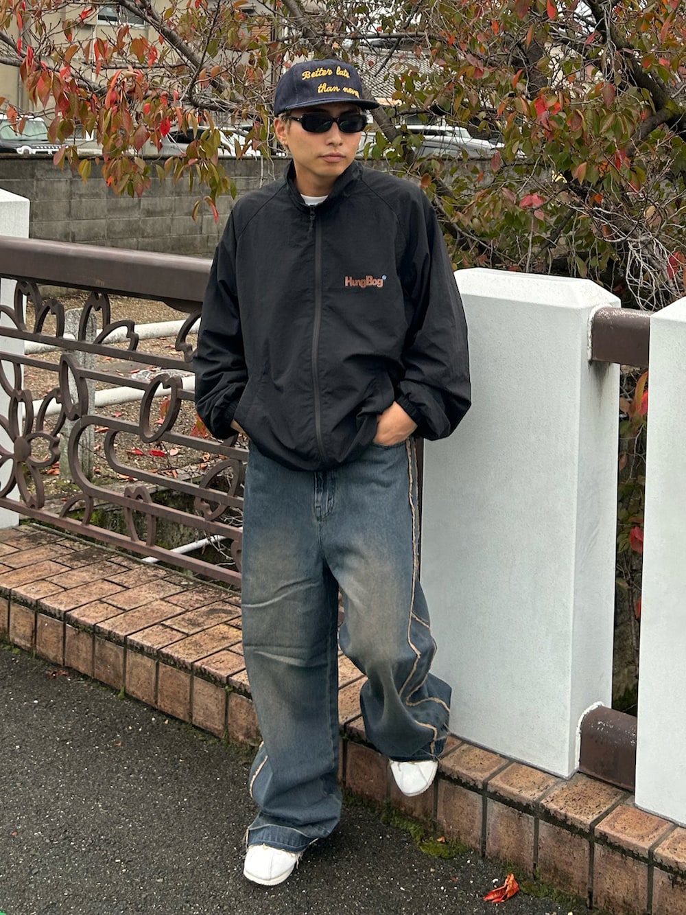 ブラック系のナイロンジャケット、ブルー系のデニムパンツ、ホワイト系のスニーカーを着用したメンズの冬コーディネートの2枚目の写真