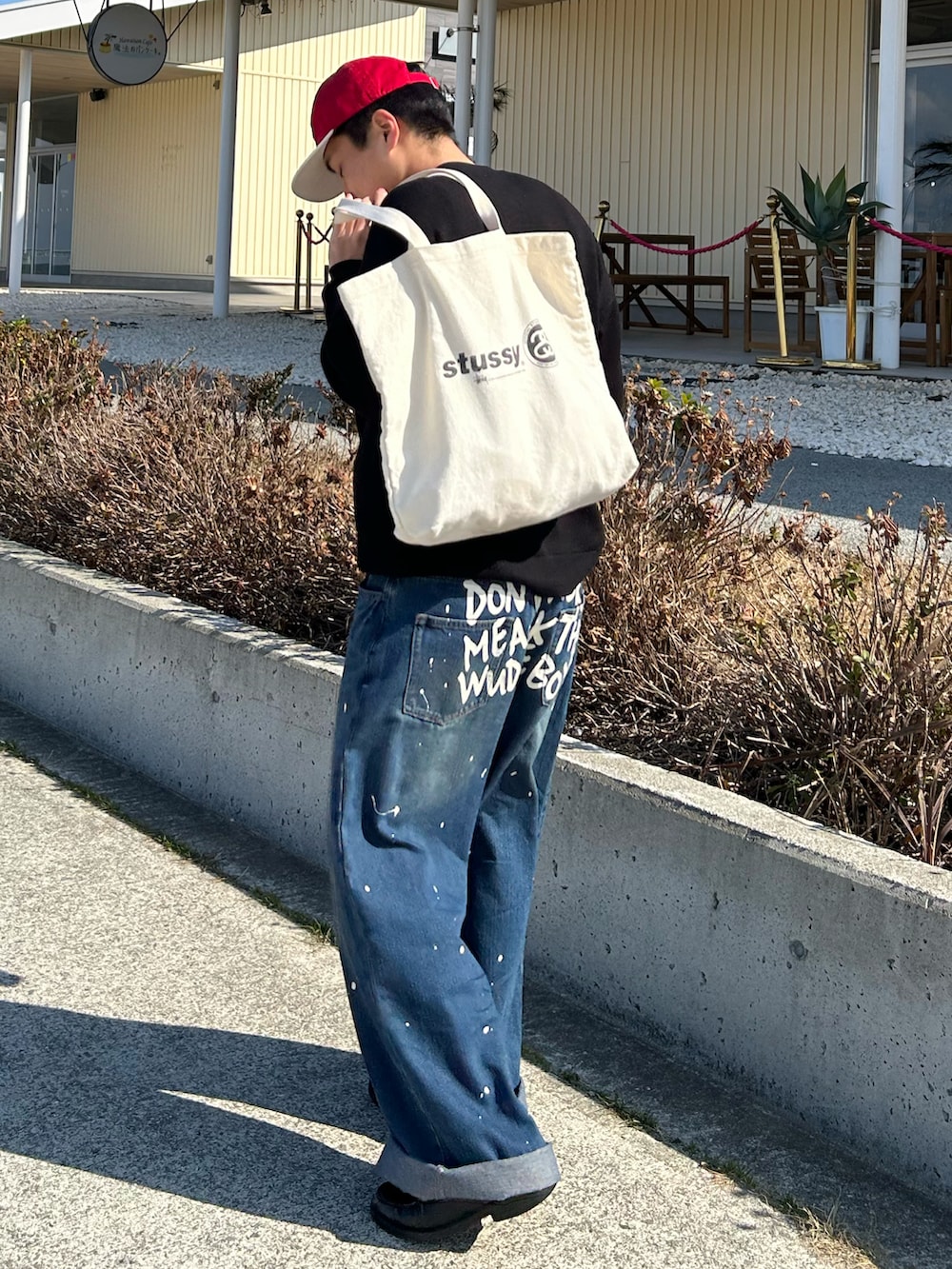 ブラック系のニット/セーター、ブルー系のデニムパンツ、ブラック系のローファーを着用したメンズの冬コーディネートの2枚目の写真