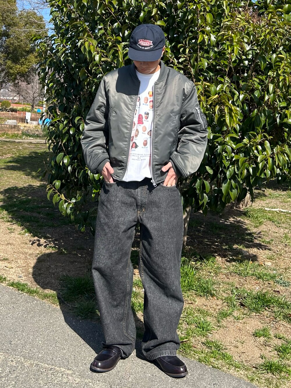 ホワイト系のTシャツ/カットソー、グリーン系のMA-1、ブラック系のデニムパンツを着用したメンズの春コーディネートの2枚目の写真
