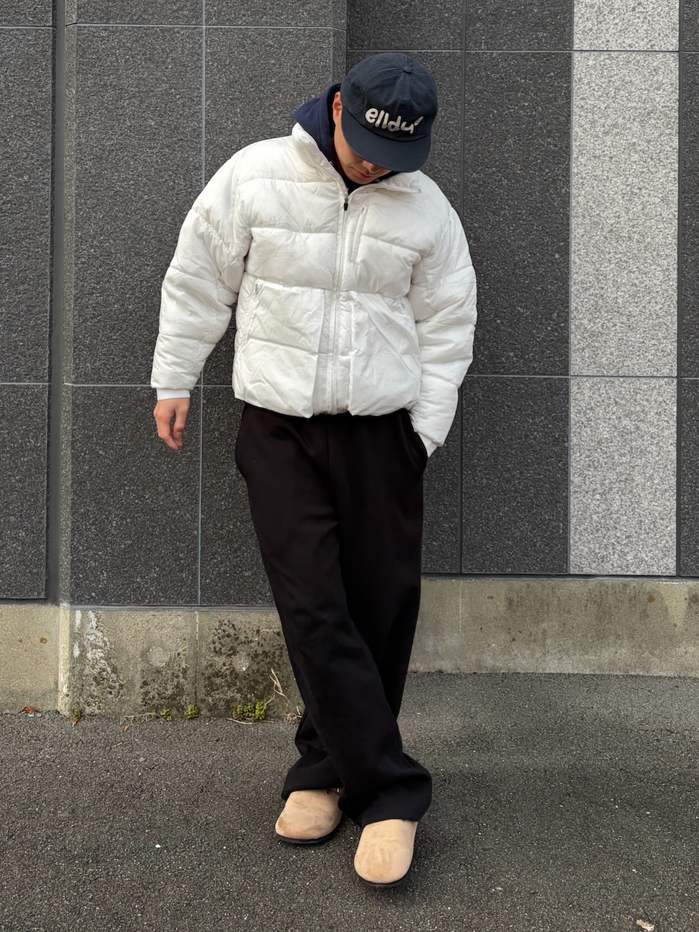 ベージュ系のサンダル、ホワイト系のダウンジャケット/コート、ブラック系のスウェットパンツを着用したメンズの春コーディネートの2枚目の写真