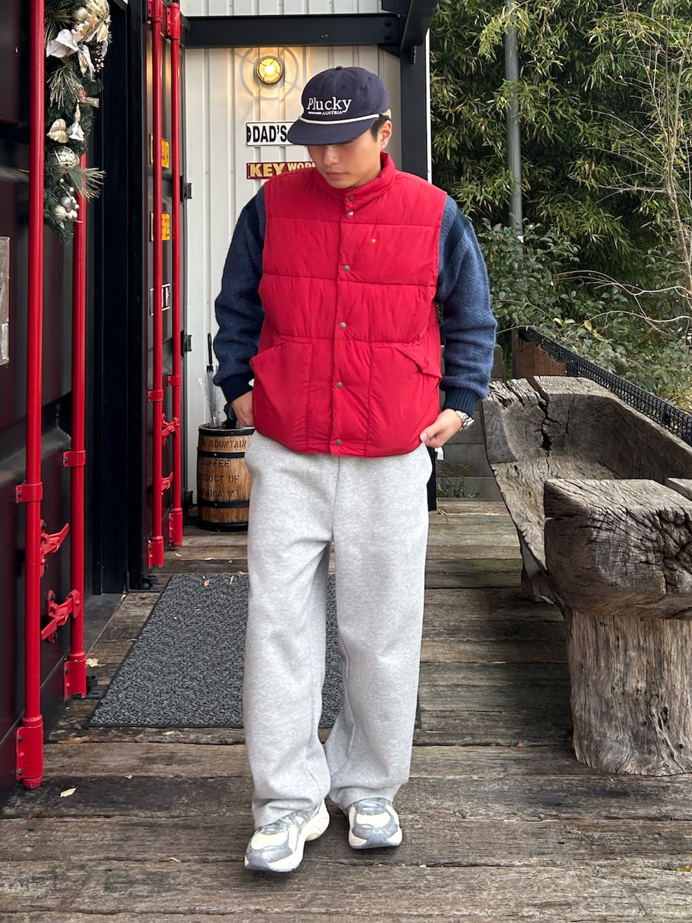 レッド系のベスト、グレー系のスウェットパンツ、シルバー系のスニーカーを着用したメンズの冬コーディネートの2枚目の写真