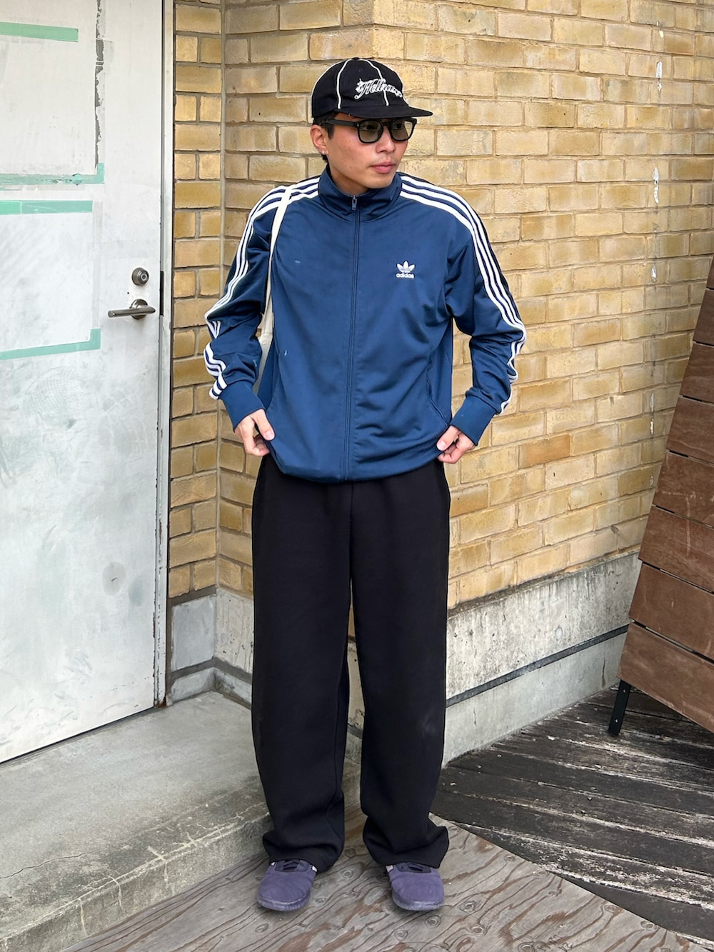 ブラック系のスウェットパンツ、パープル系のスニーカー、ブルー系のジャケット/アウターを着用したメンズの冬コーディネートの2枚目の写真