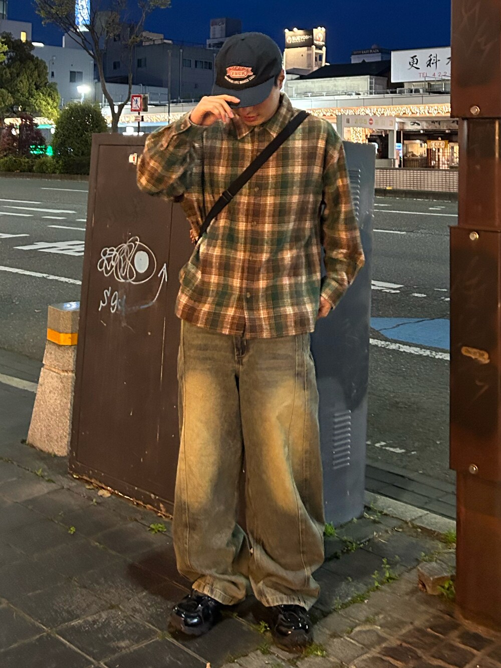 グリーン系のシャツ/ブラウス、ブルー系のデニムパンツ、ブラック系のスニーカーを着用したメンズの春コーディネートの2枚目の写真