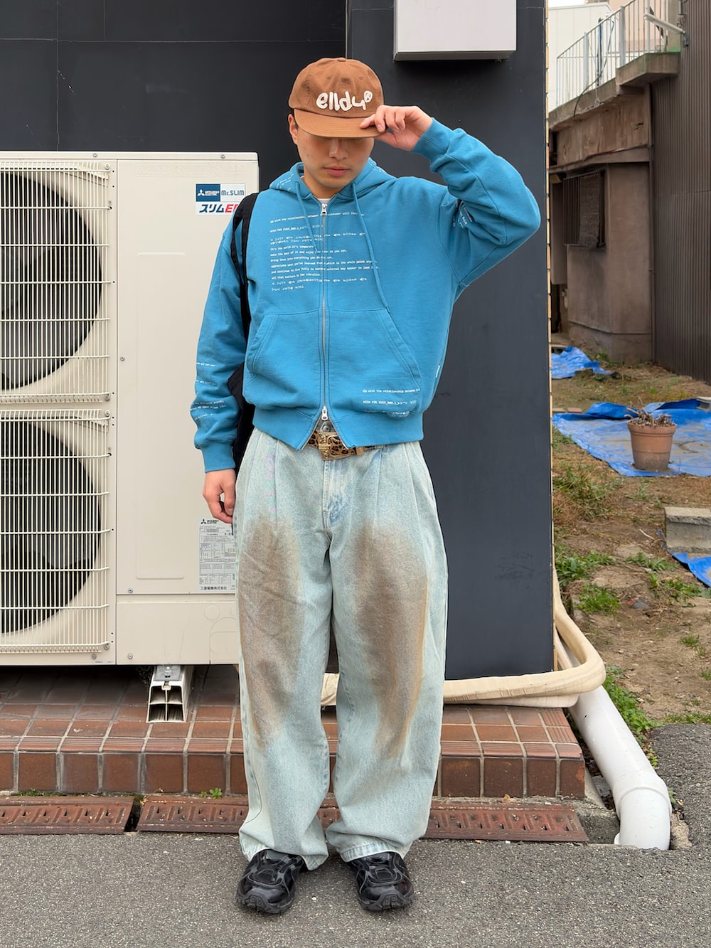 ブルー系のパーカー、ブルー系のデニムパンツ、ブラック系のスニーカーを着用したメンズの春コーディネートの2枚目の写真