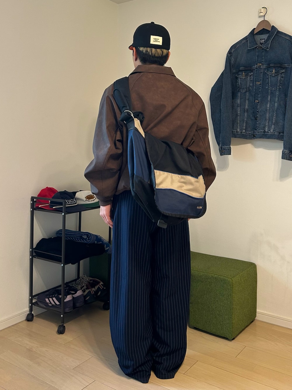 ブラウン系のブルゾン、ブルー系のスラックス、ブラック系のローファーを着用したメンズの冬コーディネートの2枚目の写真