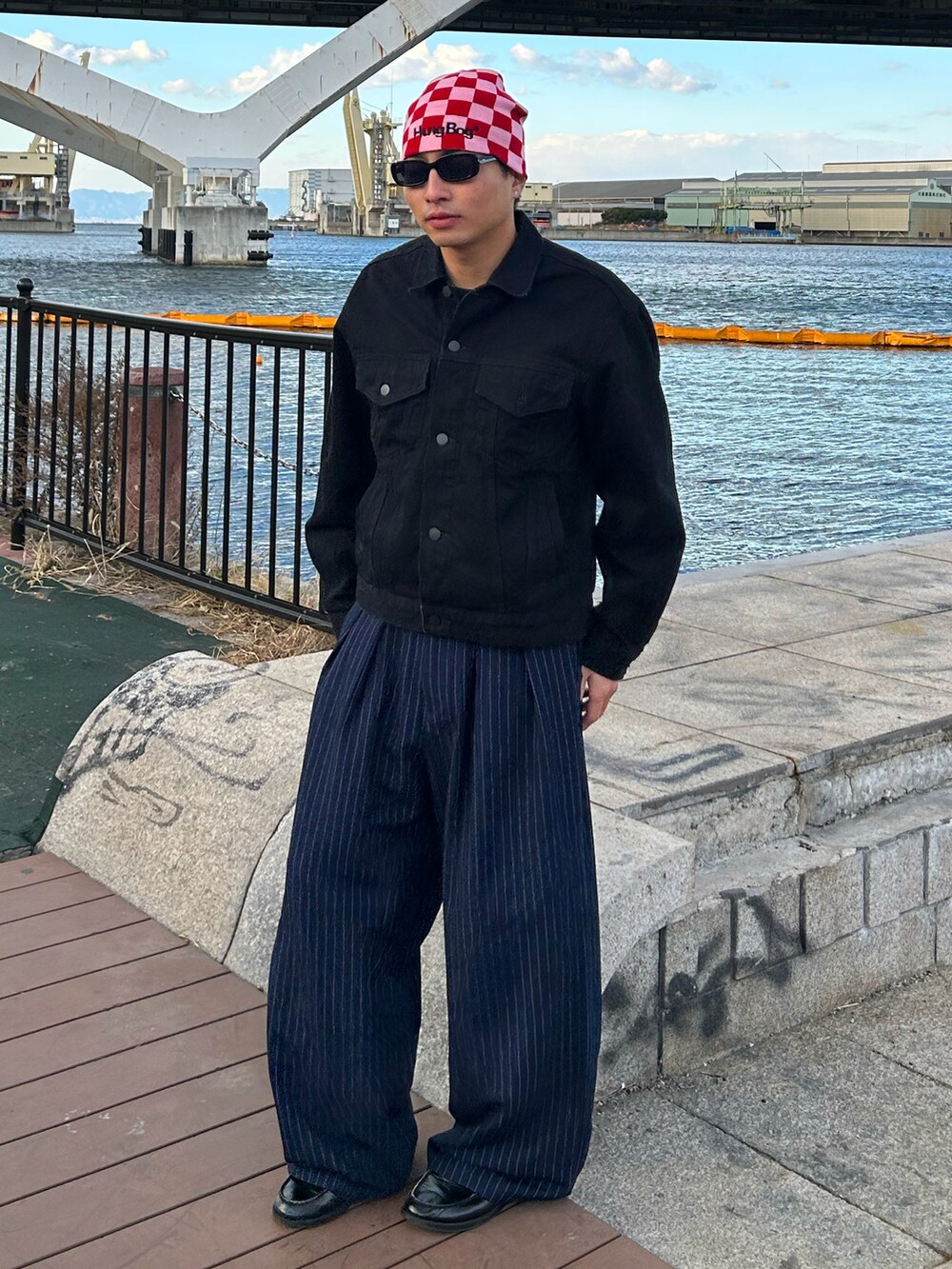 ブラック系のデニムジャケット、ブルー系のスラックス、ブラック系のローファーを着用したメンズの冬コーディネートの2枚目の写真