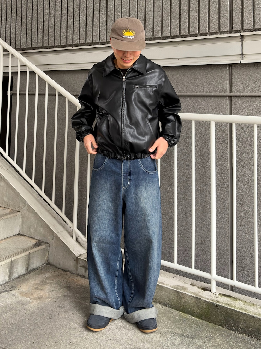 ブラック系のブルゾン、ブルー系のデニムパンツ、ブラック系のスニーカーを着用したメンズの春コーディネートの2枚目の写真