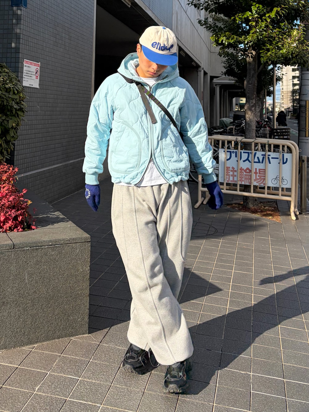 ブルー系のブルゾン、グレー系のスウェットパンツ、ブラック系のスニーカーを着用したメンズの冬コーディネートの2枚目の写真