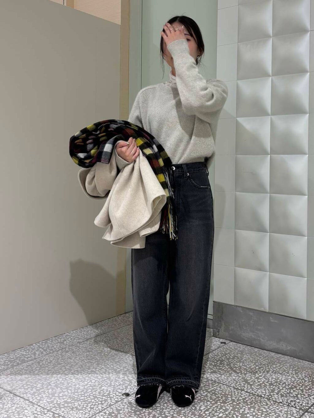 ベージュ系のピーコート、ホワイト系のTシャツ/カットソー、ブラック系のデニムパンツを着用したレディースの冬コーディネートの2枚目の写真