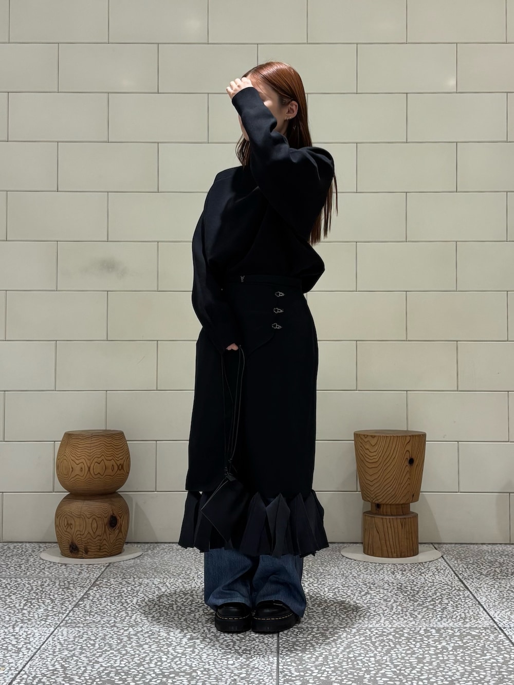 ブラック系のニット/セーター、ブルー系のその他パンツ、ブラック系のスカートを着用したレディースの秋コーディネートの2枚目の写真