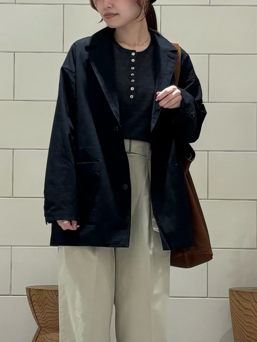 グレー系のニット/セーター、ブラウン系のトートバッグ、ブラック系のその他アウターを着用したレディースの冬コーディネートの4枚目の写真