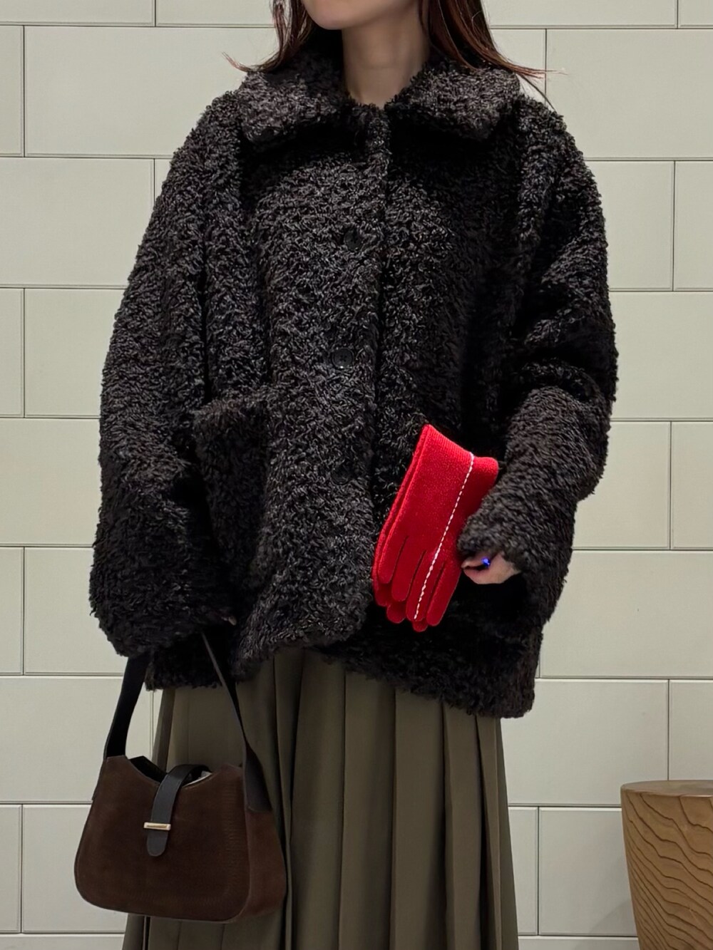 ブラウン系のスニーカー、グリーン系のスカート、ブラウン系のその他アウターを着用したレディースの秋コーディネートの4枚目の写真