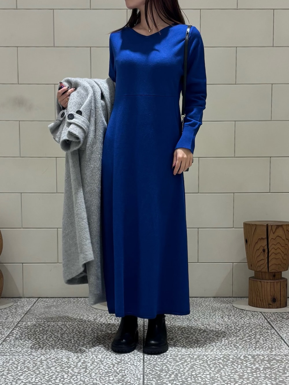 ブラック系のショルダーバッグ、ブラック系のブーツ、グレー系のその他アウターを着用したレディースの冬コーディネートの5枚目の写真