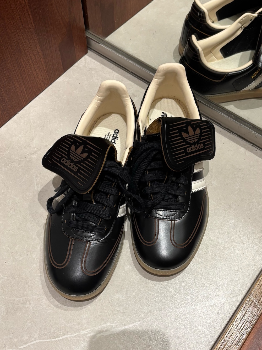 グレー系のニット/セーター、ブラウン系のトートバッグ、ブラック系のその他アウターを着用したレディースの冬コーディネートの6枚目の写真