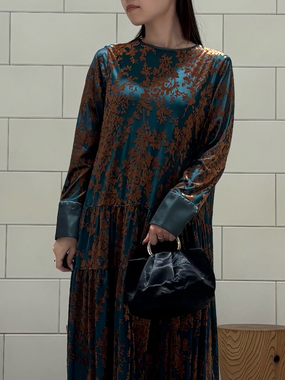 グリーン系のワンピース、ブラック系のハンドバッグ、ブラック系のバレエシューズを着用したレディースの秋コーディネートの4枚目の写真