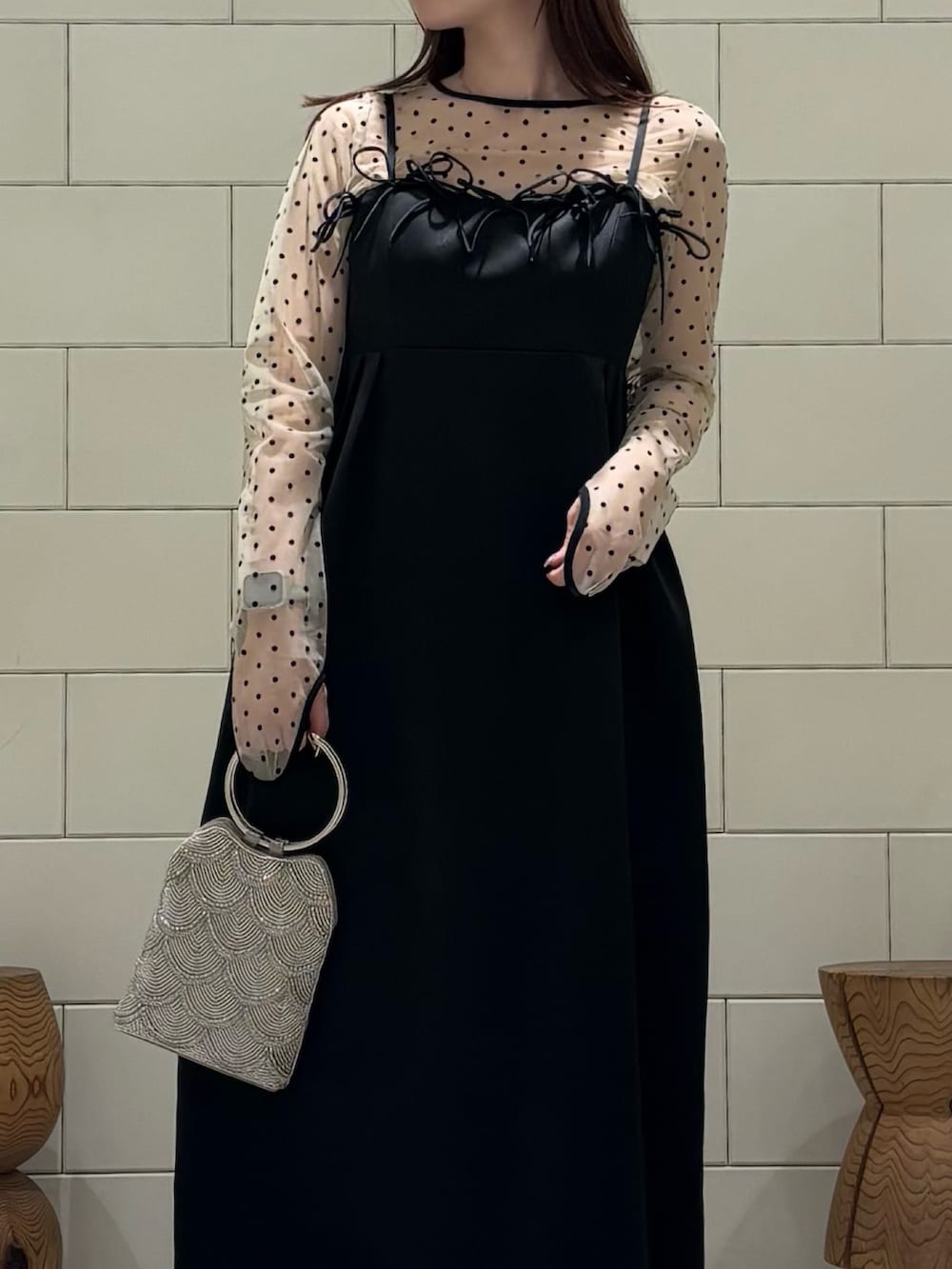 ブラック系のパンプス、ベージュ系のハンドバッグを着用したレディースの春コーディネートの3枚目の写真