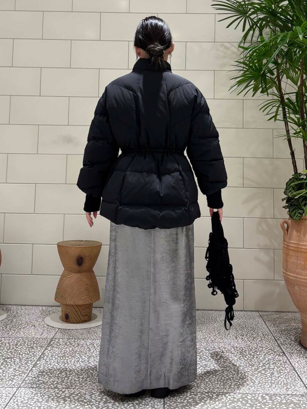 ブラック系のダウンジャケット/コート、シルバー系のスカート、レッド系のニット/セーターを着用したレディースの冬コーディネートの4枚目の写真