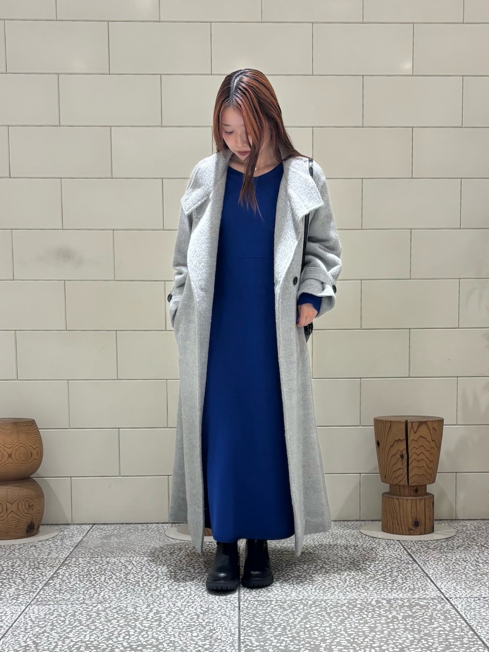 ブラック系のショルダーバッグ、ブラック系のブーツ、グレー系のその他アウターを着用したレディースの冬コーディネートの2枚目の写真