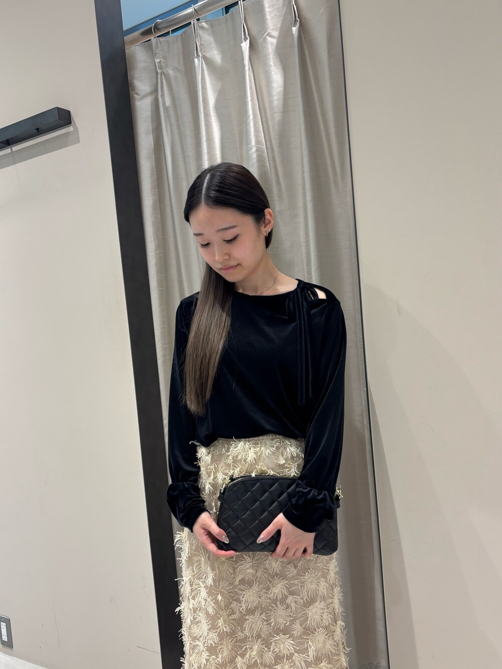 ベージュ系のスカート、ブラック系のTシャツ/カットソー、ブラック系のショルダーバッグを着用したレディースの秋コーディネートの4枚目の写真