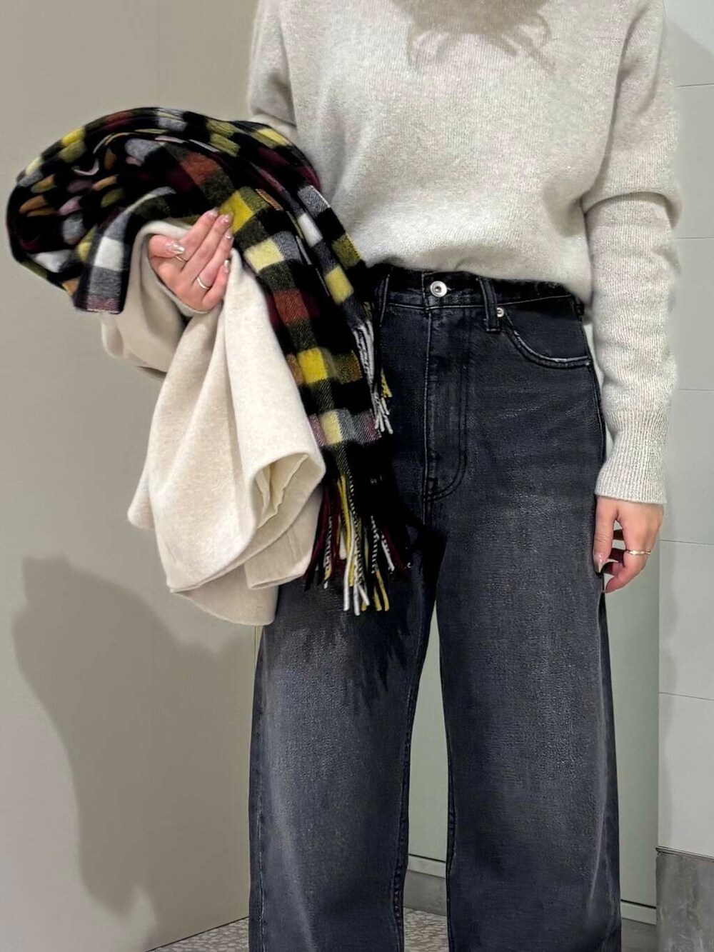 ベージュ系のピーコート、ホワイト系のTシャツ/カットソー、ブラック系のデニムパンツを着用したレディースの冬コーディネートの5枚目の写真