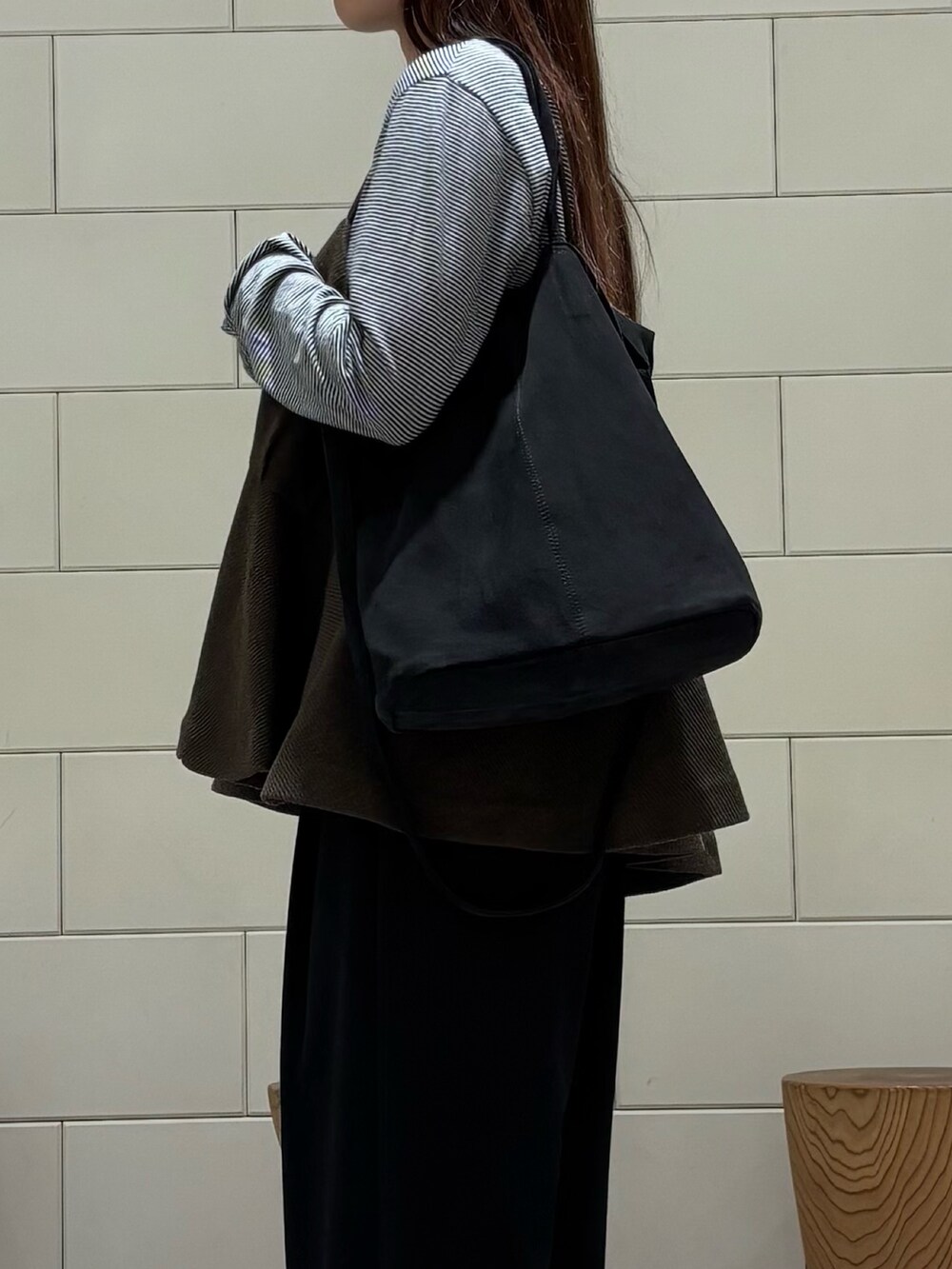 ブラック系のTシャツ/カットソー、ブラック系のその他パンツ、グリーン系のトートバッグを着用したレディースの秋コーディネートの5枚目の写真