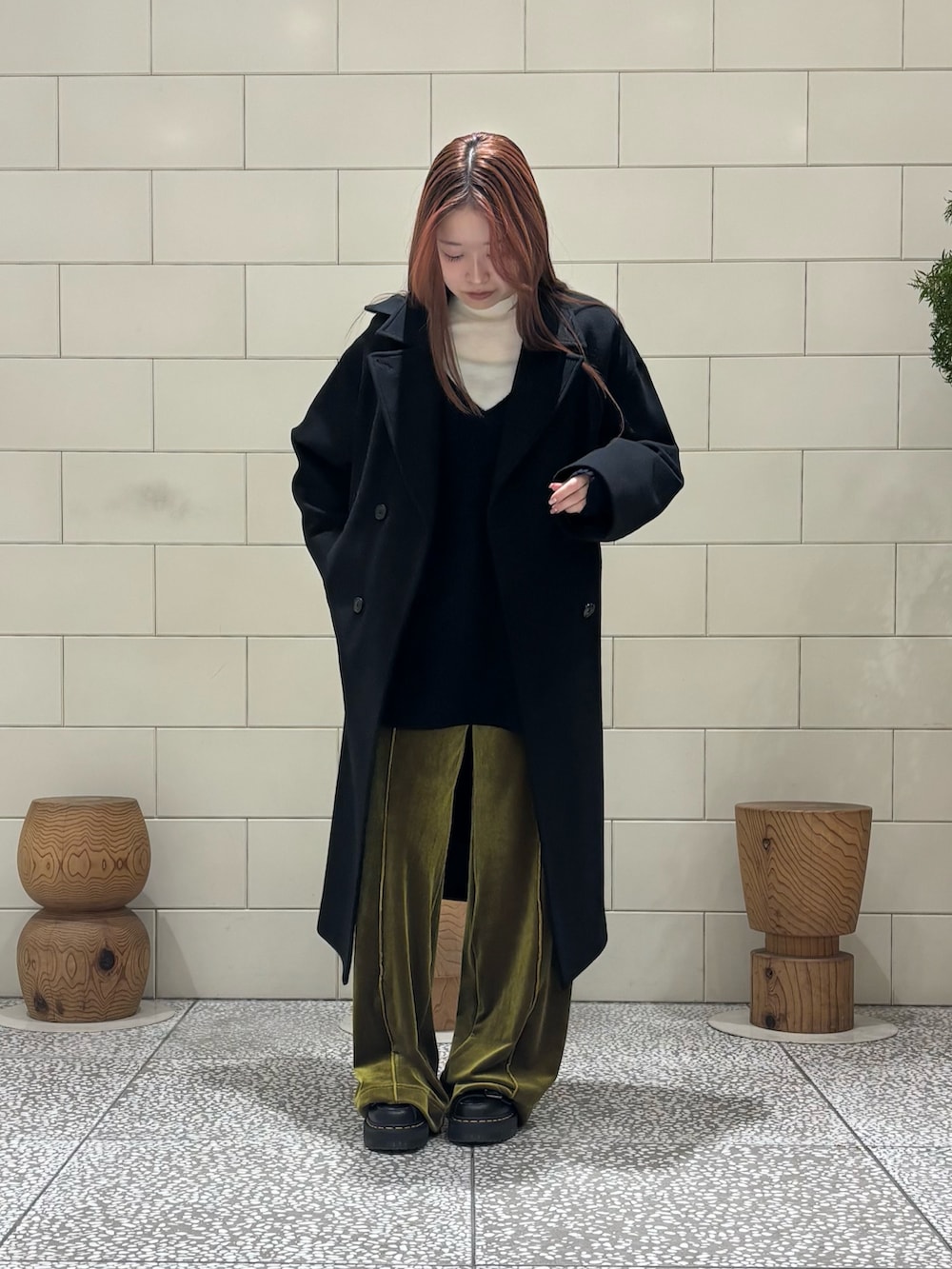 ホワイト系のニット/セーター、ブルー系のニット/セーター、ブラック系のチェスターコートを着用したレディースの冬コーディネートの2枚目の写真