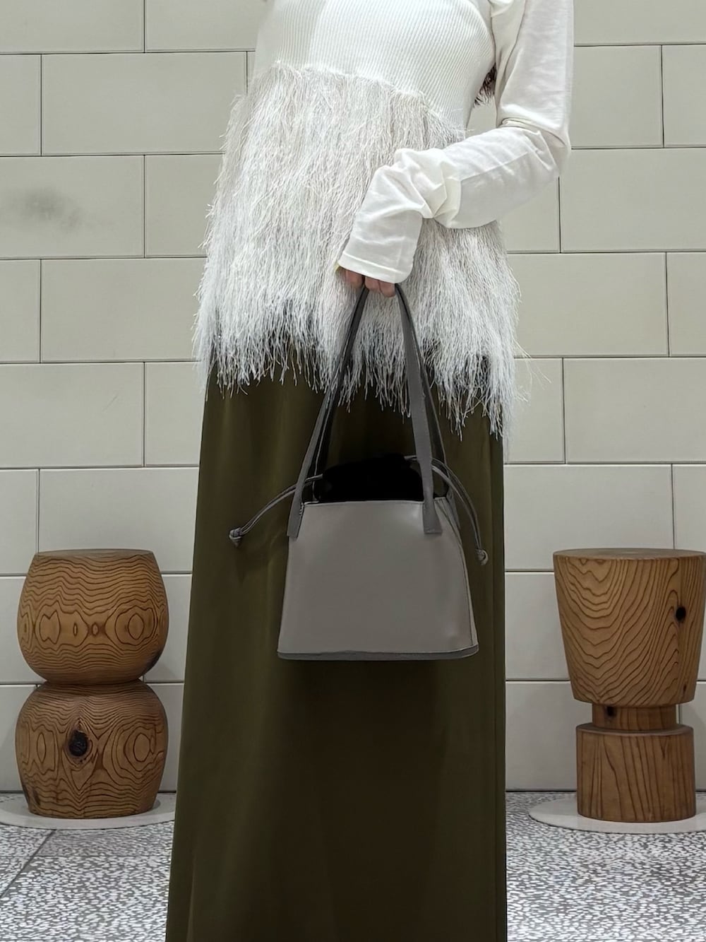 ホワイト系のTシャツ/カットソー、ホワイト系のニット/セーター、グリーン系のスカートを着用したレディースの秋コーディネートの3枚目の写真