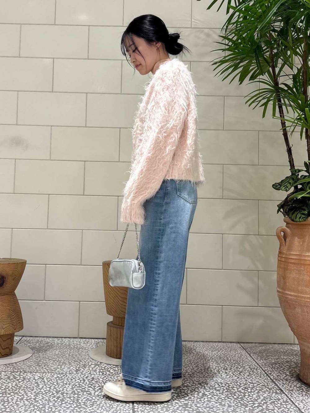 ピンク系のTシャツ/カットソー、ブルー系のデニムパンツ、シルバー系のショルダーバッグを着用したレディースの冬コーディネートの2枚目の写真