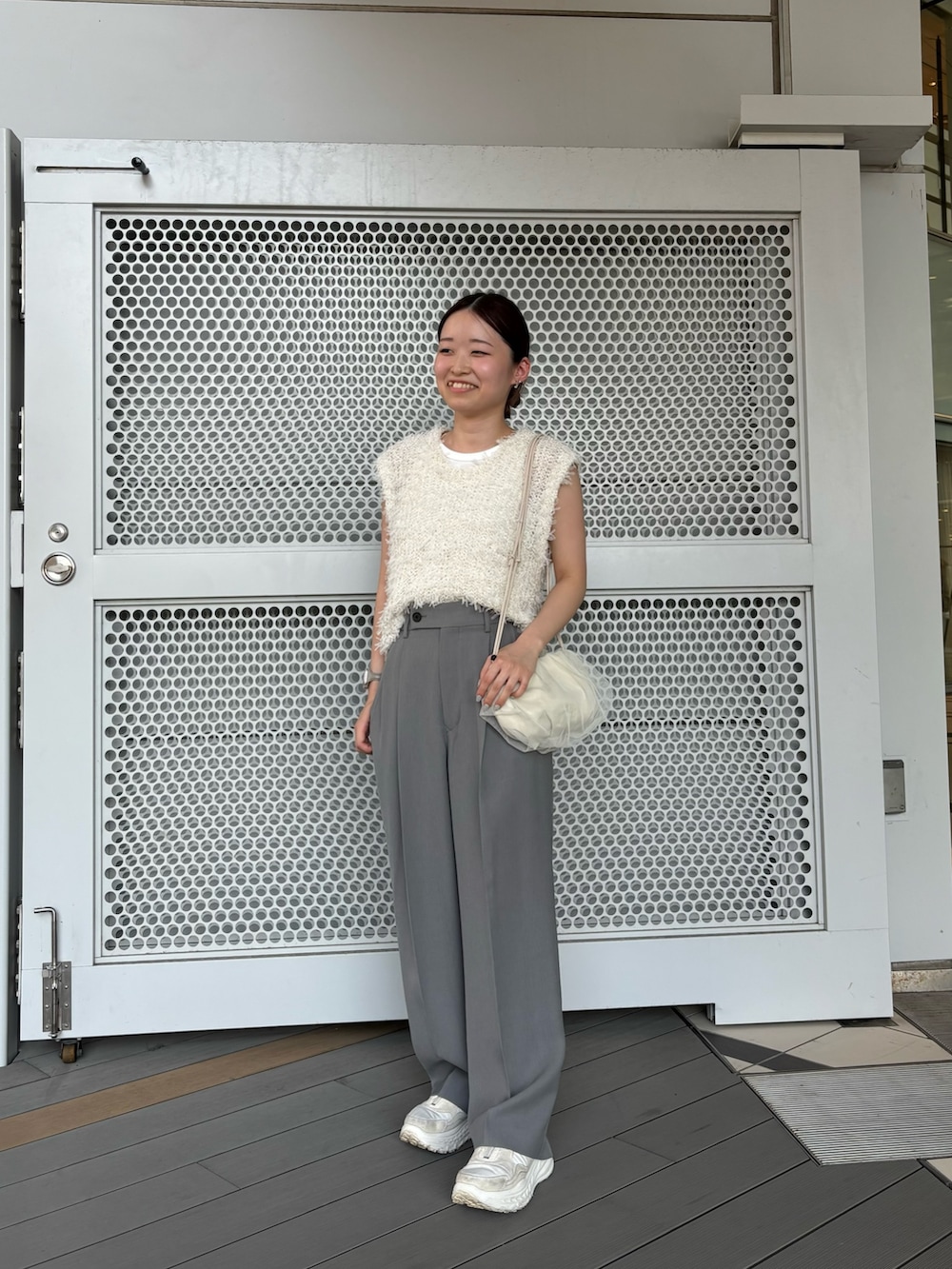 グレー系のその他パンツ、ホワイト系のショルダーバッグ、ホワイト系のベストを着用したレディースの夏コーディネートの2枚目の写真
