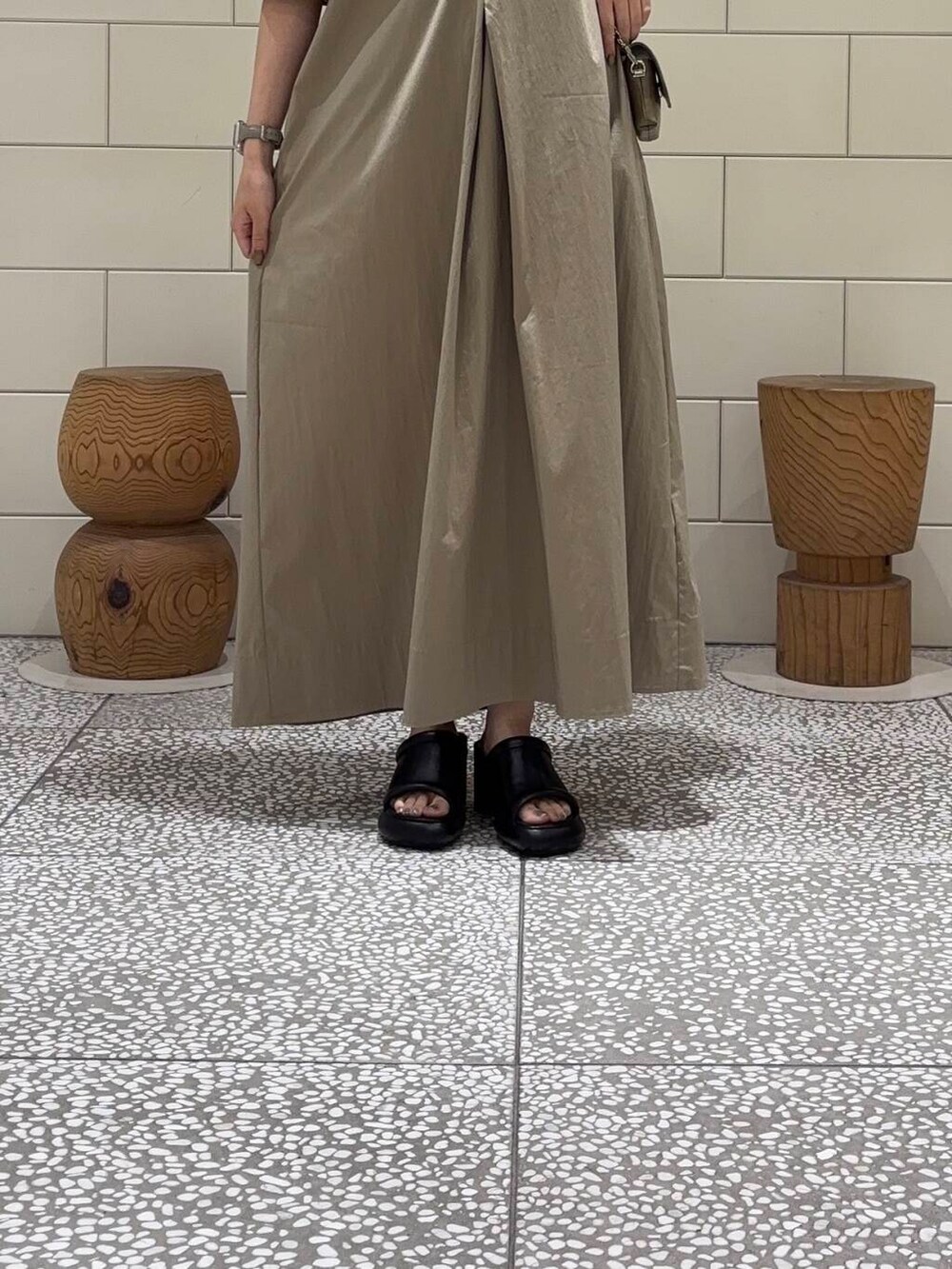 グリーン系のショルダーバッグ、ベージュ系のワンピースを着用したレディースの夏コーディネートの5枚目の写真