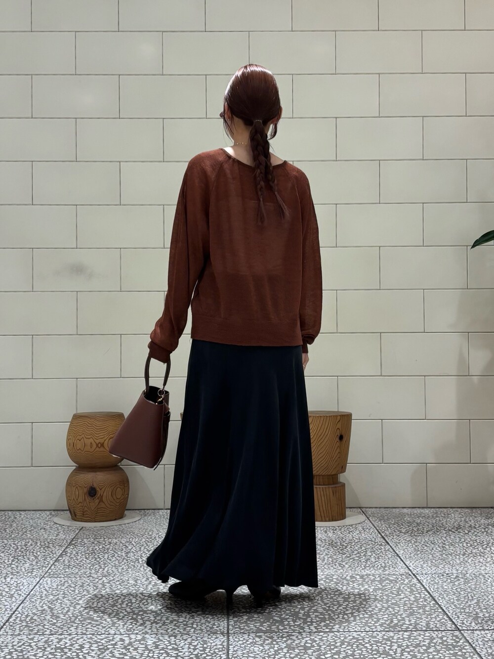 ブラック系のスカート、ブラック系のブーツ、ブラウン系のカーディガン/ボレロを着用したレディースの秋コーディネートの2枚目の写真