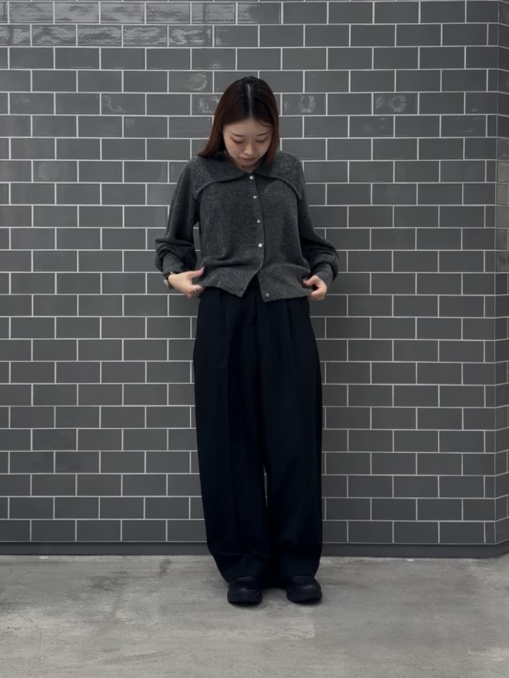 グレー系のニット/セーター、ブラック系のその他パンツ、ブラック系のスニーカーを着用したレディースの秋コーディネートの2枚目の写真