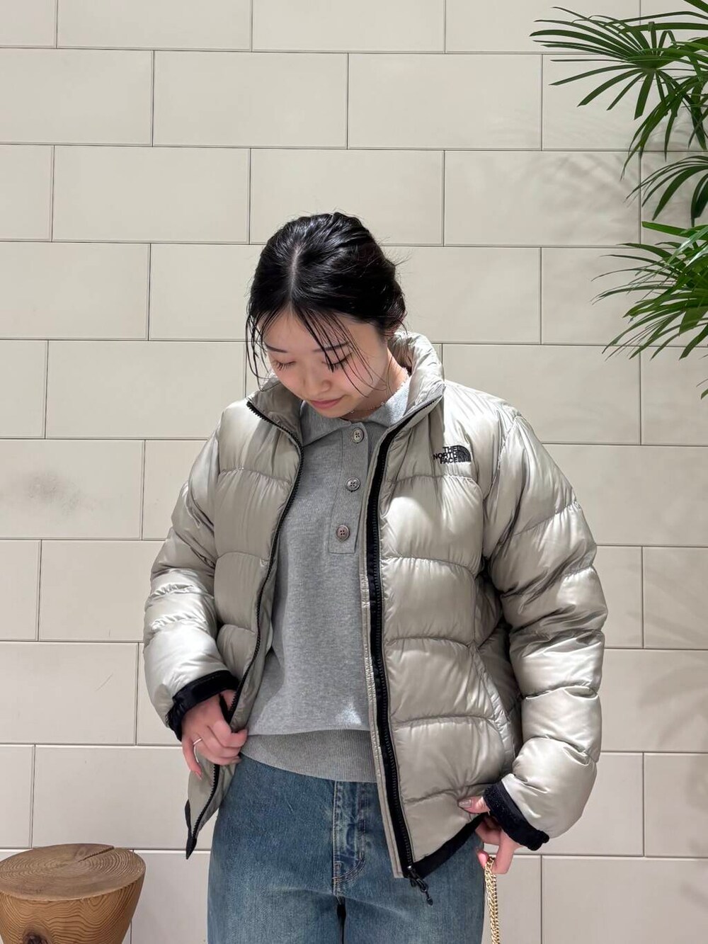 ホワイト系のスニーカー、グレー系のダウンジャケット/コート、ブルー系のデニムパンツを着用したレディースの冬コーディネートの5枚目の写真