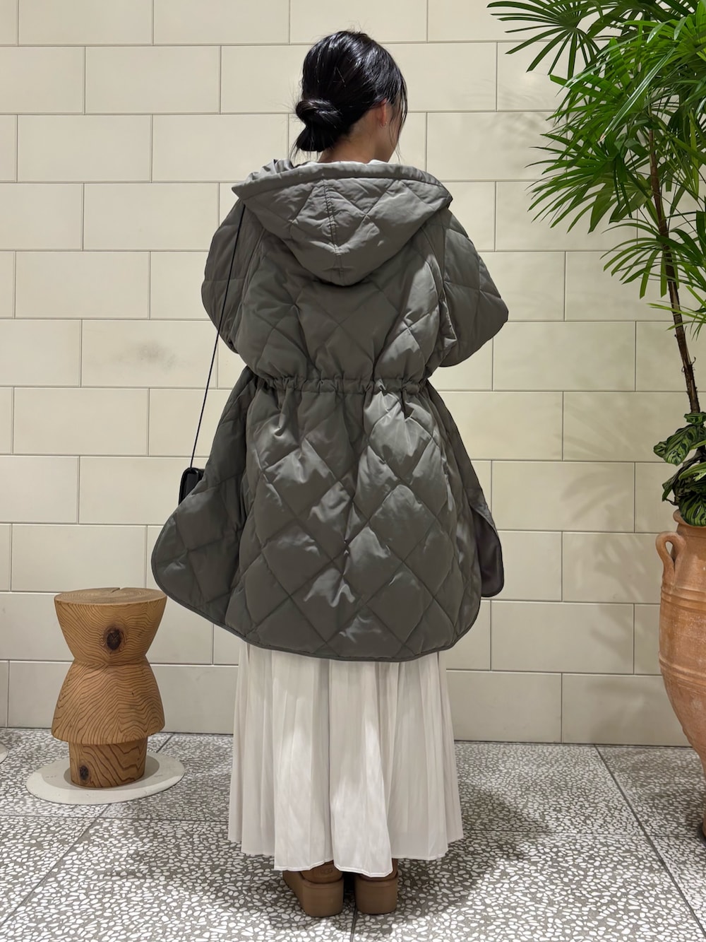 ブラウン系のニット/セーター、グレー系のダウンジャケット/コート、ブラック系のショルダーバッグを着用したレディースの冬コーディネートの4枚目の写真