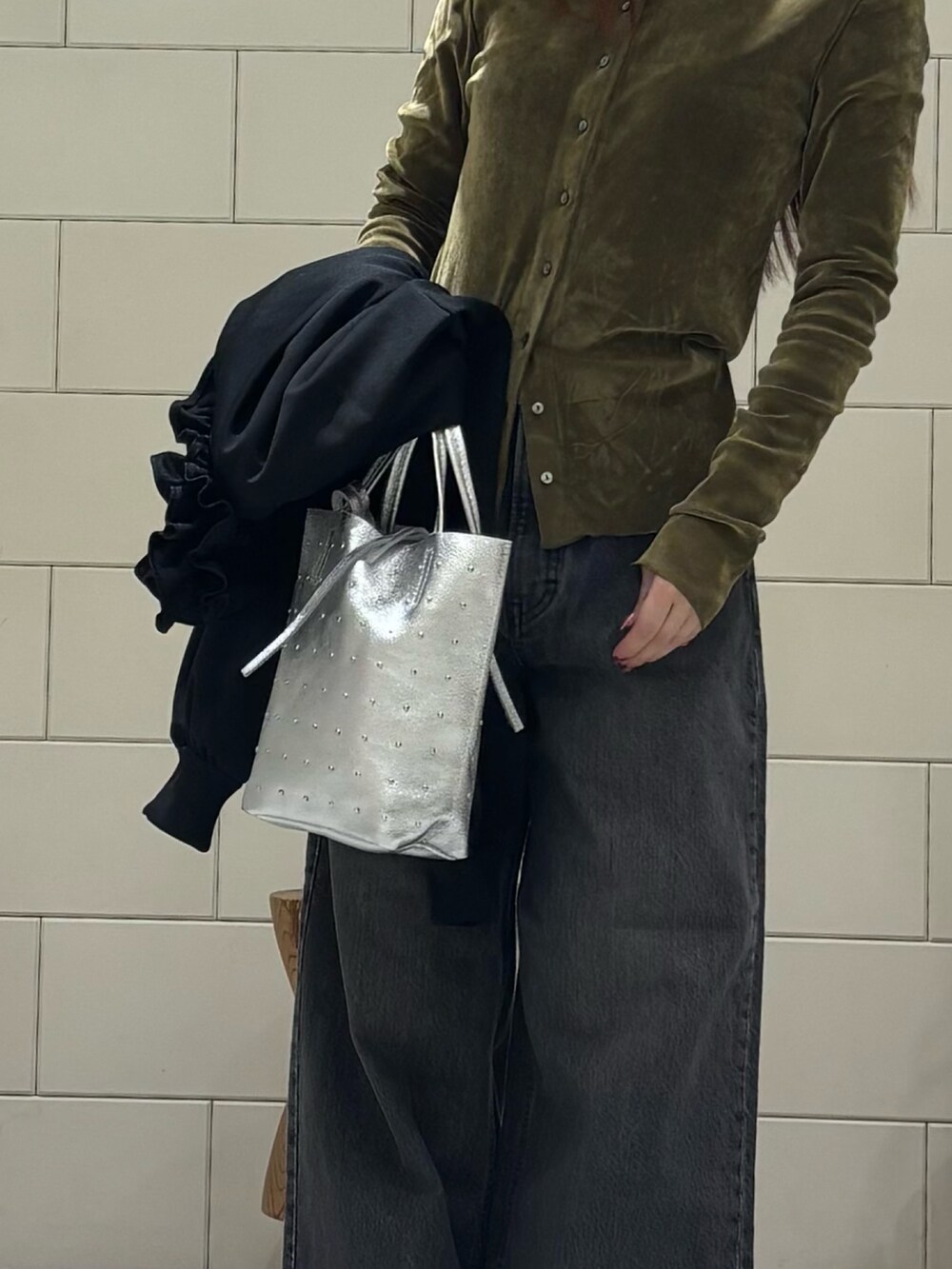 ブラック系のブルゾン、グリーン系のカーディガン/ボレロ、ブラック系のデニムパンツを着用したレディースの冬コーディネートの4枚目の写真