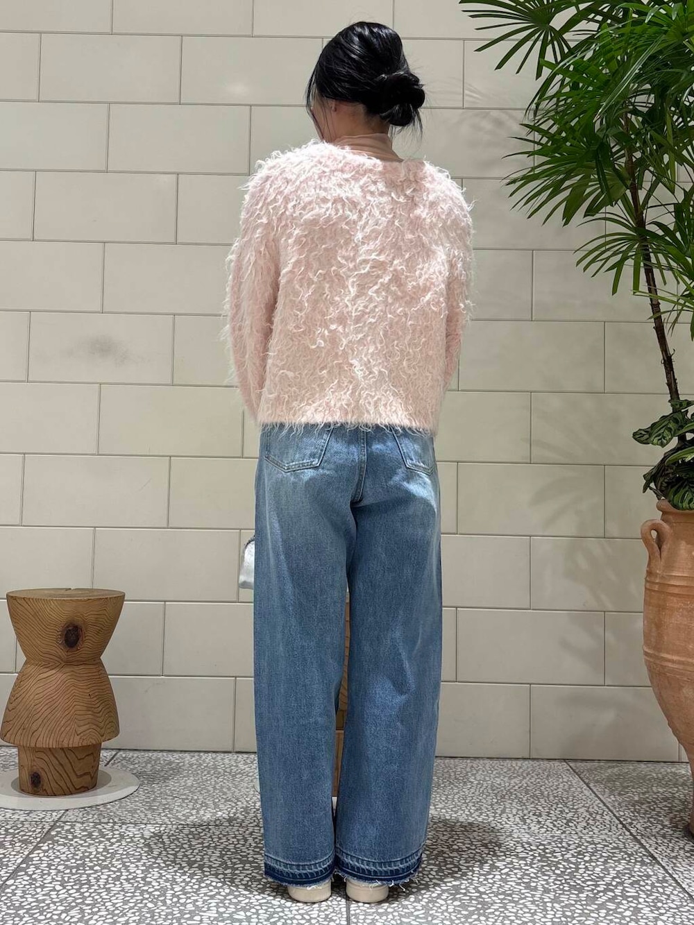 ピンク系のTシャツ/カットソー、ブルー系のデニムパンツ、シルバー系のショルダーバッグを着用したレディースの冬コーディネートの3枚目の写真