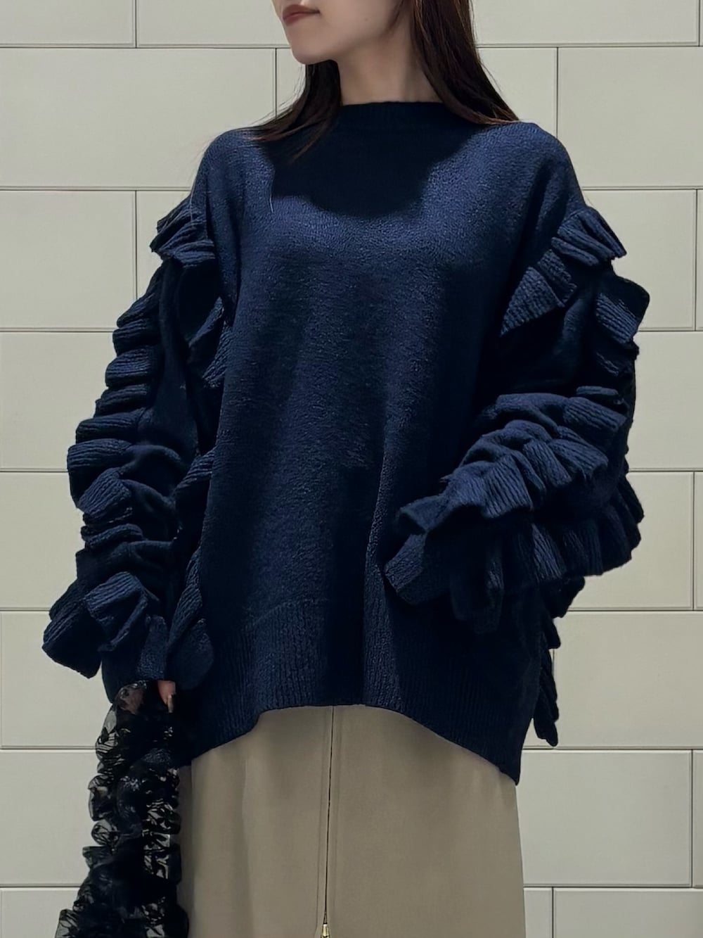 ブラック系のダウンジャケット/コート、ブラック系のニット/セーター、ベージュ系のスカートを着用したレディースの冬コーディネートの6枚目の写真