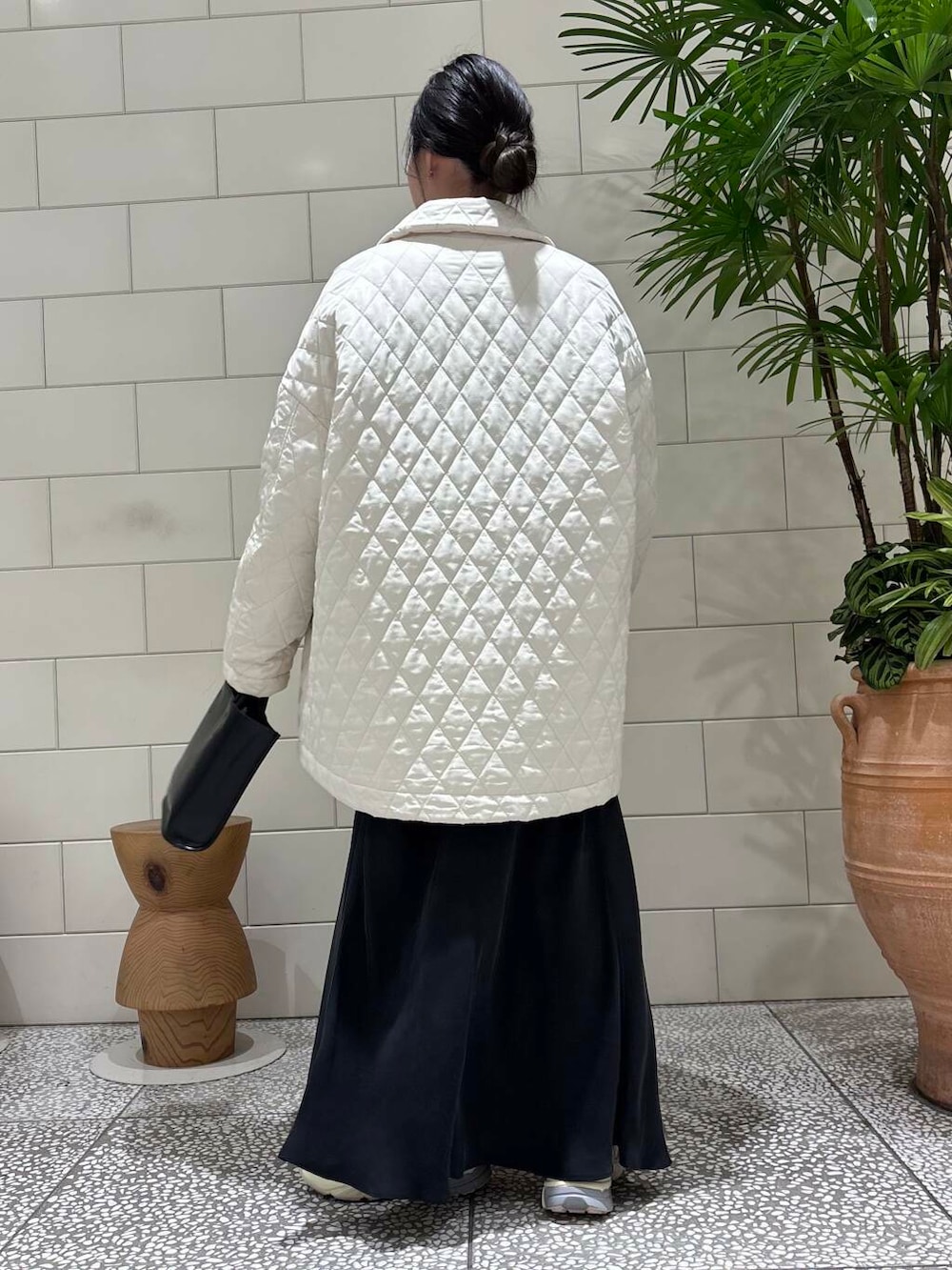 ホワイト系のスニーカー、ブラック系のトートバッグ、ブラウン系のニット/セーターを着用したレディースの冬コーディネートの2枚目の写真